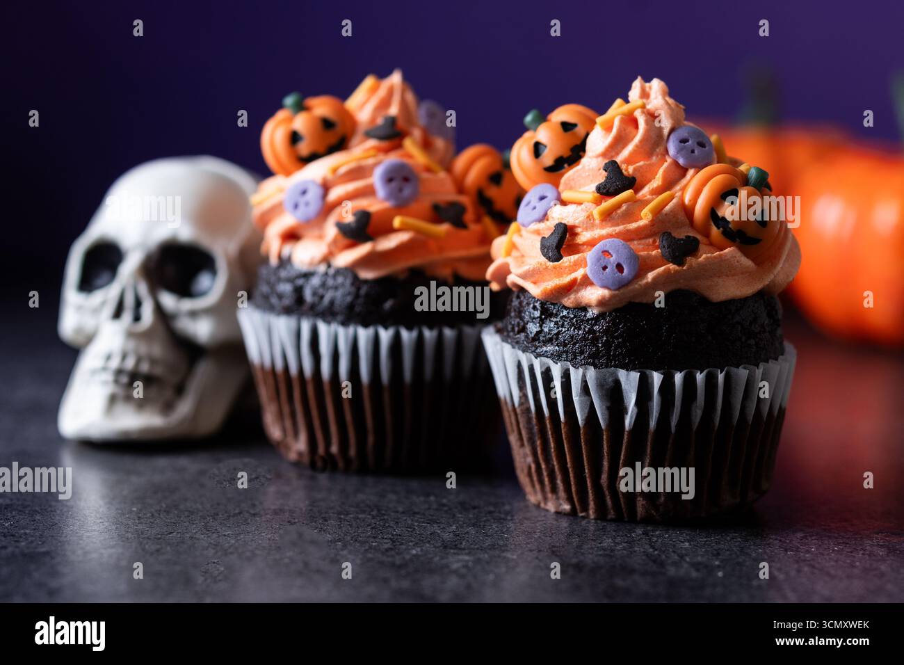 Cupcakes d'Halloween avec des saupoudrages de citrouille sur fond sombre Banque D'Images