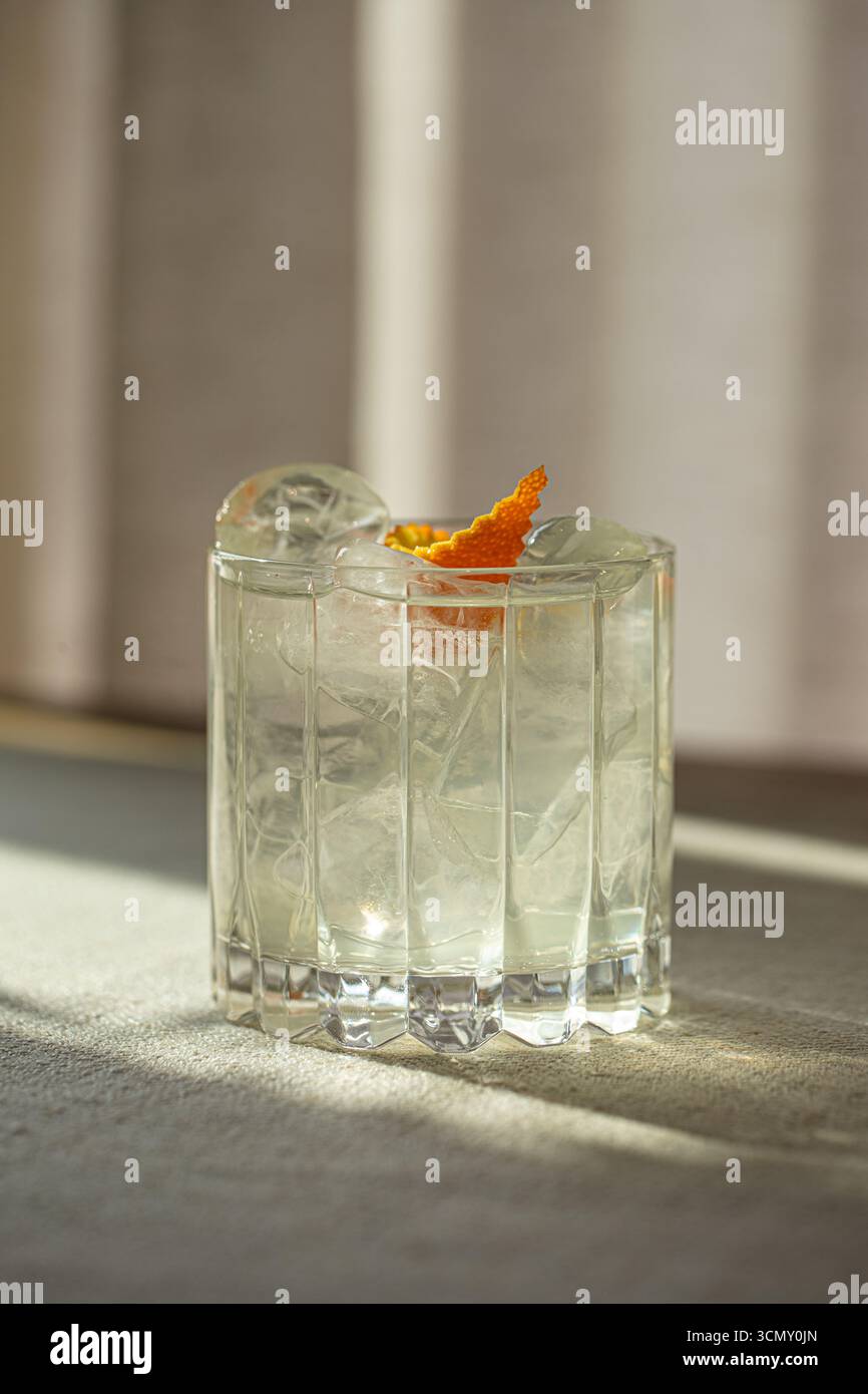 Gin et cocktail tonique avec glace dans un verre à facettes Banque D'Images