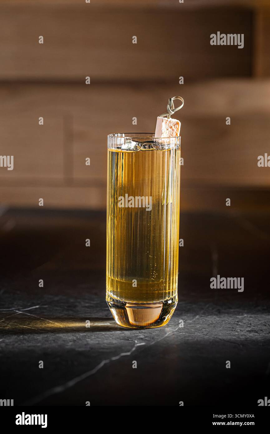 Cocktail highball avec glaçon et lueur dorée Banque D'Images