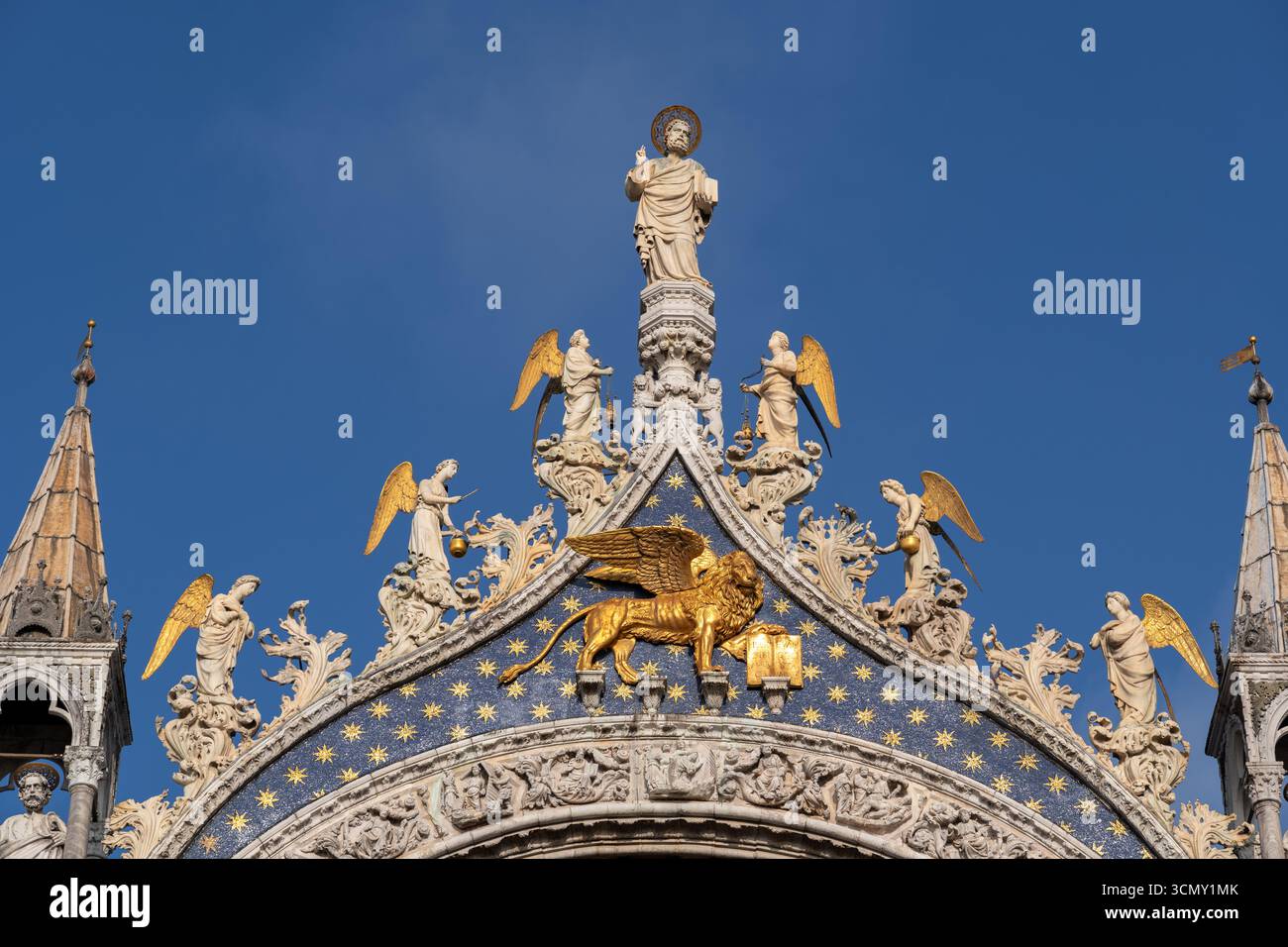 Statue de Saint Marc flanquée d'anges et Lion ailé doré de Saint Marc sur le sommet de la façade occidentale de la basilique Mark à Venise, Italie. Banque D'Images