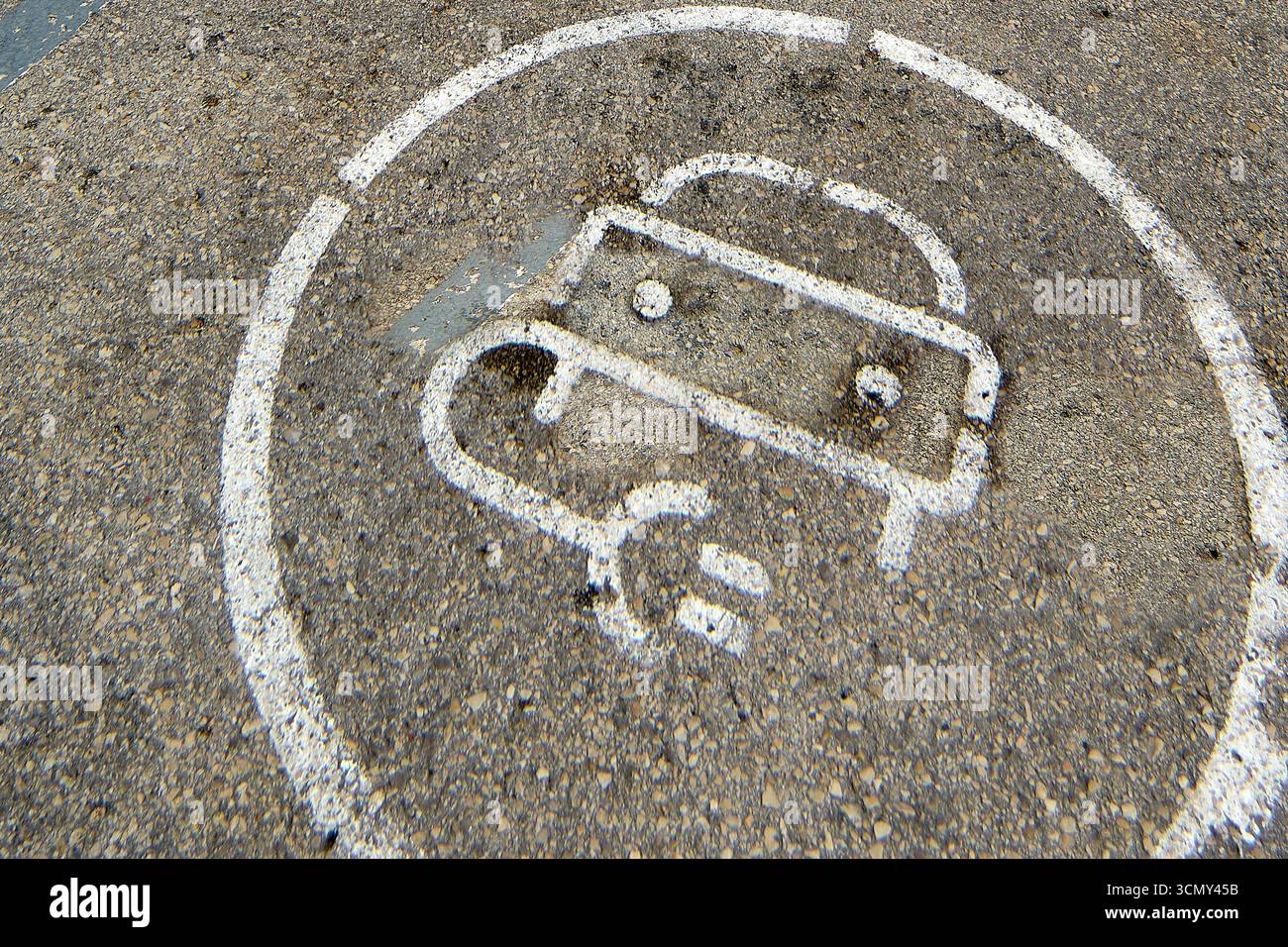 Symbole de recharge de voiture électrique peint sur la rue. Cette image en gros plan montre la signalisation sur l'asphalte pour les véhicules de nouvelle technologie. Banque D'Images