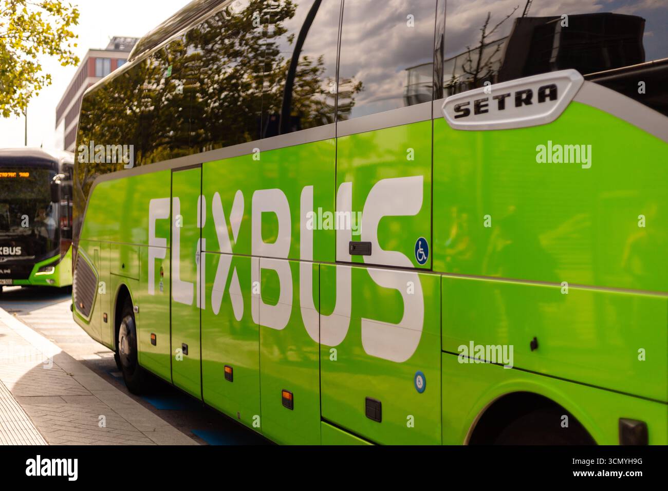 Berlin, Allemagne - 1er septembre 2025 : les bus stationnent dans un terminal FlixBus à Berlin, prêts à accueillir les passagers. Le soleil brille, mettant en valeur le vibra Banque D'Images