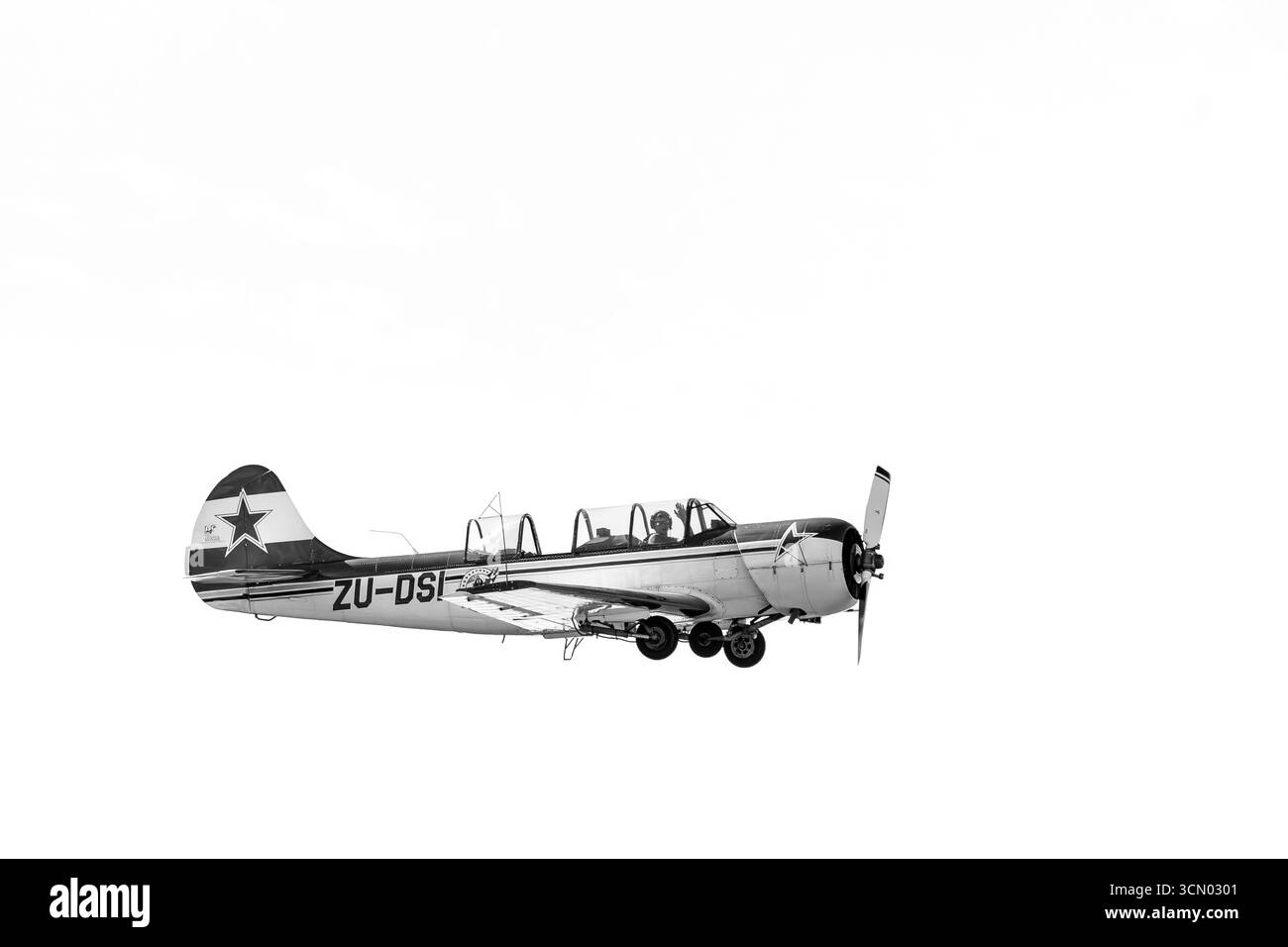 Bloemfontein, Afrique du Sud - 20 mai 2023 : un Yakovlev Yak-52 en vol à l'aéroport de Tempe à Bloemfontein. Monochrome Banque D'Images