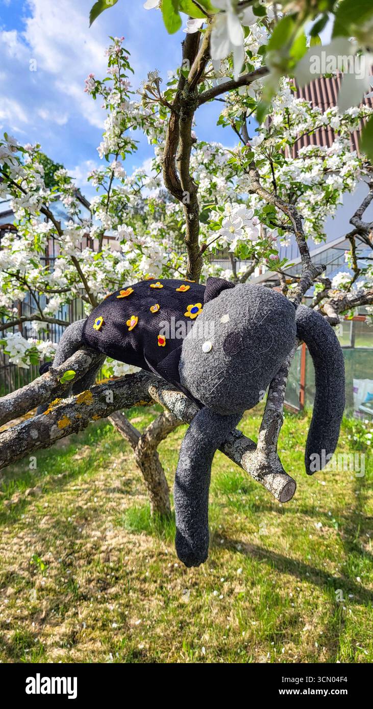 Butée de tirage. Chat rayé peluche unique fabriqué à la main reposant sur une branche d'arbre Banque D'Images