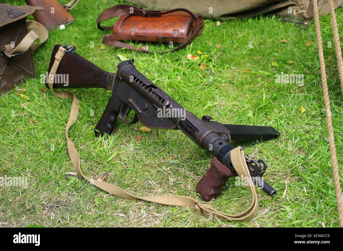 Un pistolet britannique Sten de la seconde Guerre mondiale avec sangle en toile posée dans l'herbe. Banque D'Images
