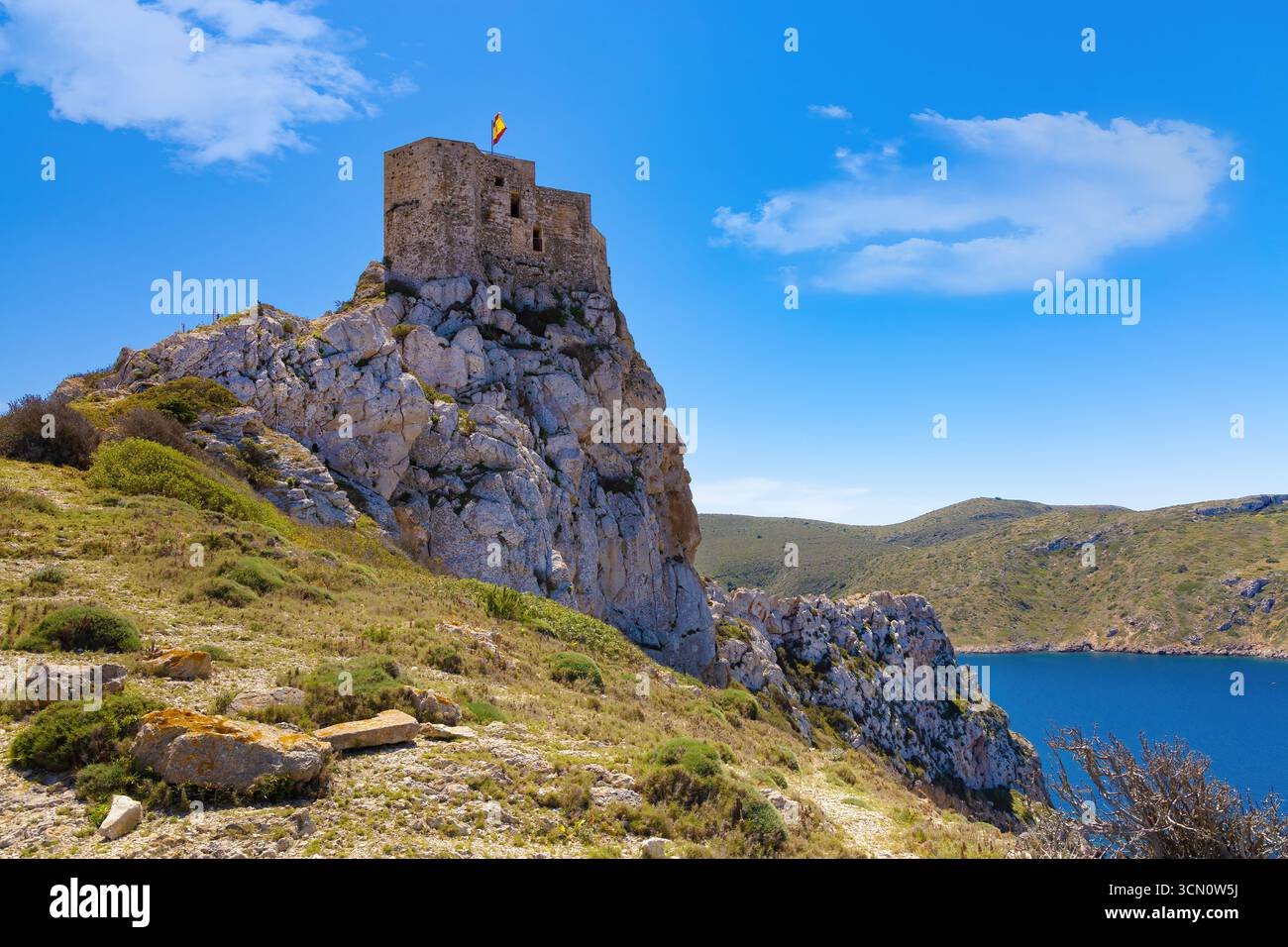 Tour octogonale du château de Cabrera, située à l'entrée du port surplombant la baie et l'île de la Gomera. Îles Baléares, Espagne Banque D'Images