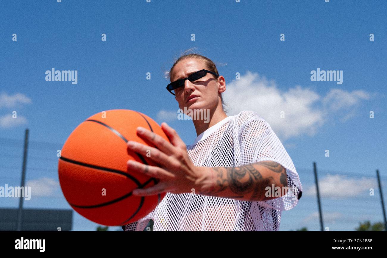 Jeune femme à la mode avec basket-ball, style urbain de rue. Banque D'Images