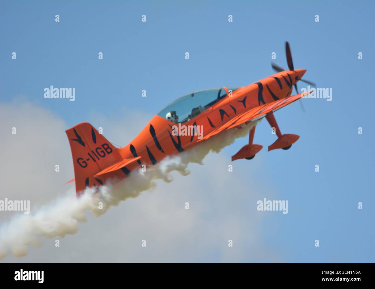 Montée de fusée, traînant de la fumée, par un avion de voltige Game composites GB1 GameBird à l'aérodrome de Sywell, Northamptonshire Banque D'Images