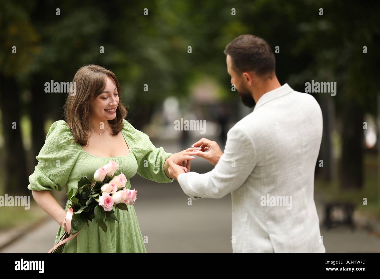Faire une proposition en mariage. Homme mettant la bague de fiançailles sur le doigt de sa copine dehors Banque D'Images