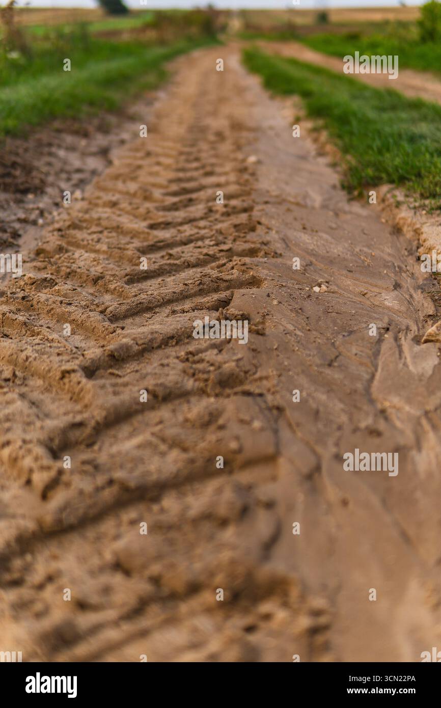 gros plan des chenilles d'un tracteur sur un chemin de terre Banque D'Images