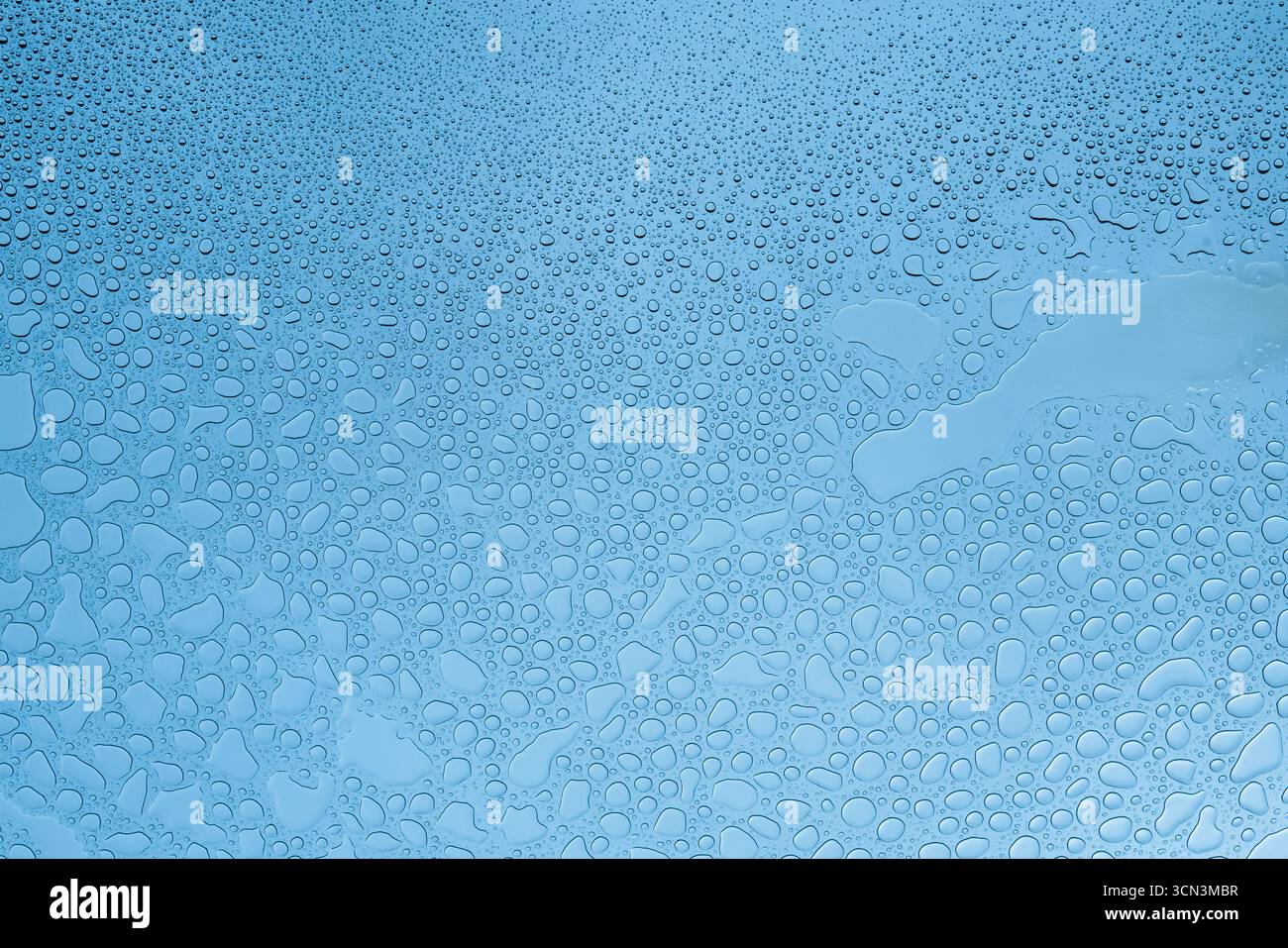 Gouttes d'eau sur verre à la température de couleur bleue Banque D'Images