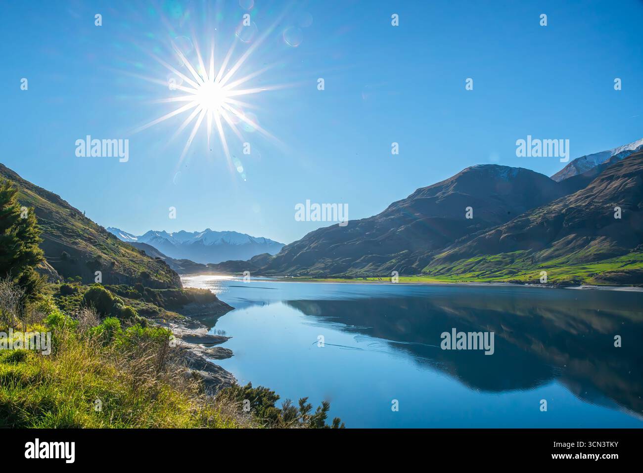 Côte au lac Wanaka par une belle journée ensoleillée avec une lumière de soleil dans le ciel sans nuages Banque D'Images