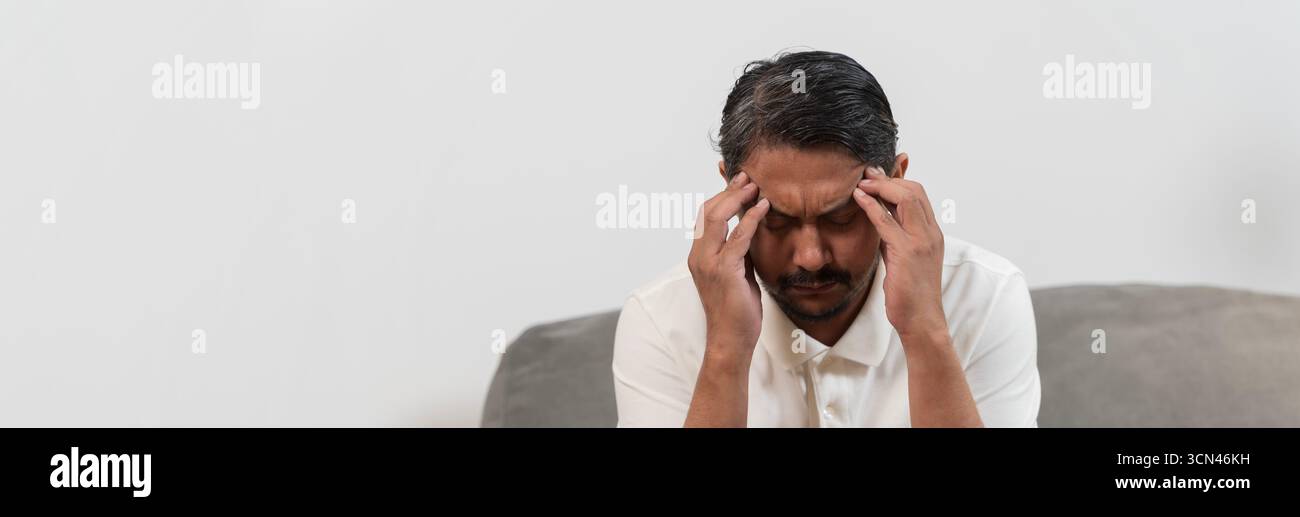 Gros plan de l'homme d'âge moyen tenant la tête avec les mains touchant les tempes, souffrant de maux de tête graves, de stress ou de migraine, concept de problème de santé, m Banque D'Images