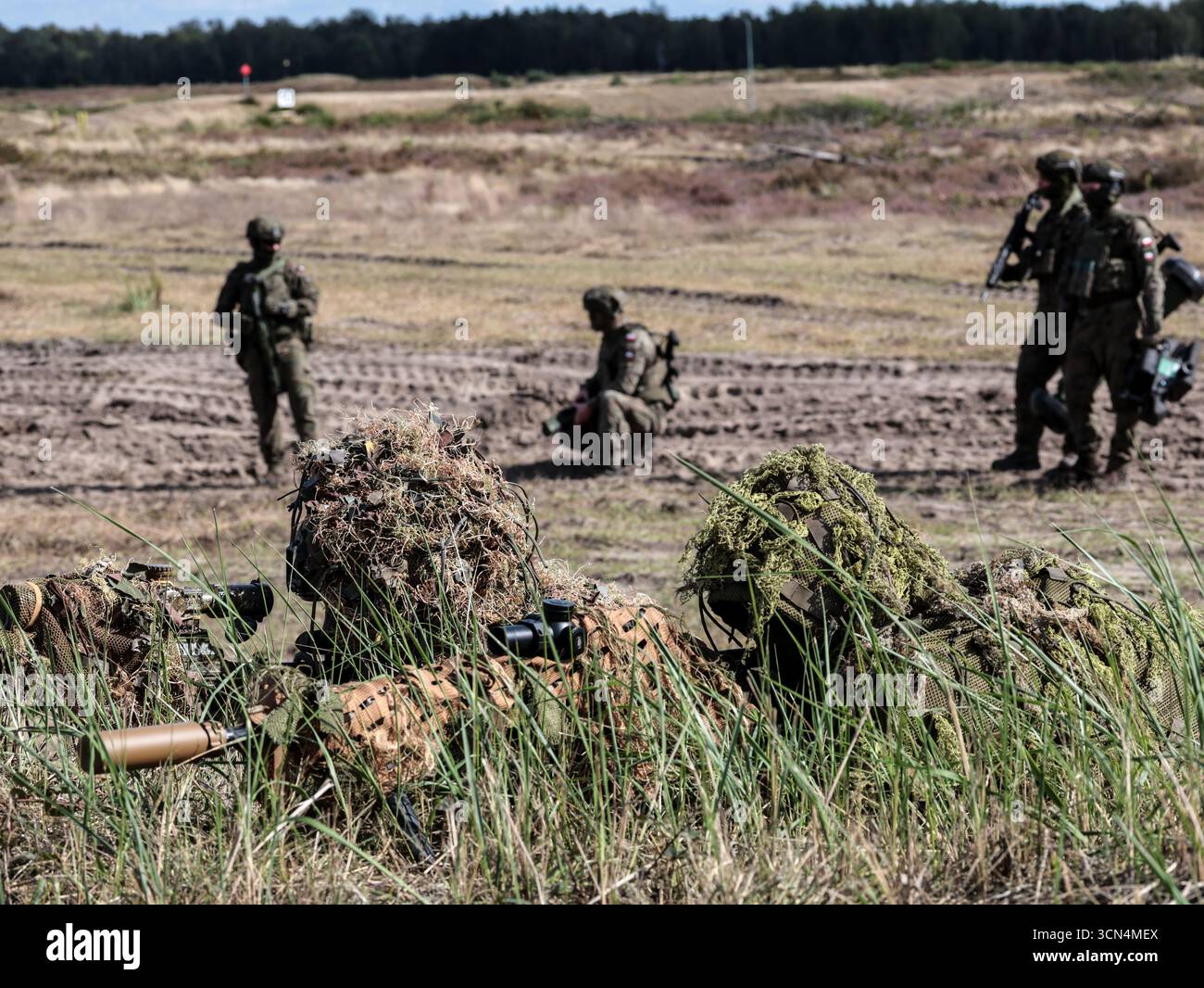 Les tireurs d'élite polonais vus sous couvert des Forces de défense territoriale s'entraînent au tir réel pour une attaque surprise avec des canons Sako M10 et Grot lors de la journée médiatique Iron Defender 25. L’exercice Iron Defender 25 est l’événement d’entraînement le plus important et le plus important planifié par et pour les forces armées polonaises. Il s'agit d'une série d'exercices défensifs menés sur terre, dans les airs et sur l'eau par les forces terrestres, aériennes, navales, spéciales et territoriales de défense. Trente mille soldats et 600 pièces d'équipement des forces armées polonaises et des alliés de l'OTAN y participent. Banque D'Images Les tireurs d'élite polonais vus sous couvert des Forces de défense territoriale s'entraînent au tir réel pour une attaque surprise avec des canons Sako M10 et Grot lors de la journée médiatique Iron Defender 25. L’exercice Iron Defender 25 est l’événement d’entraînement le plus important et le plus important planifié par et pour les forces armées polonaises. Il s'agit d'une série d'exercices défensifs menés sur terre, dans les airs et sur l'eau par les forces terrestres, aériennes, navales, spéciales et territoriales de défense. Trente mille soldats et 600 pièces d'équipement des forces armées polonaises et des alliés de l'OTAN y participent. Banque D'Images