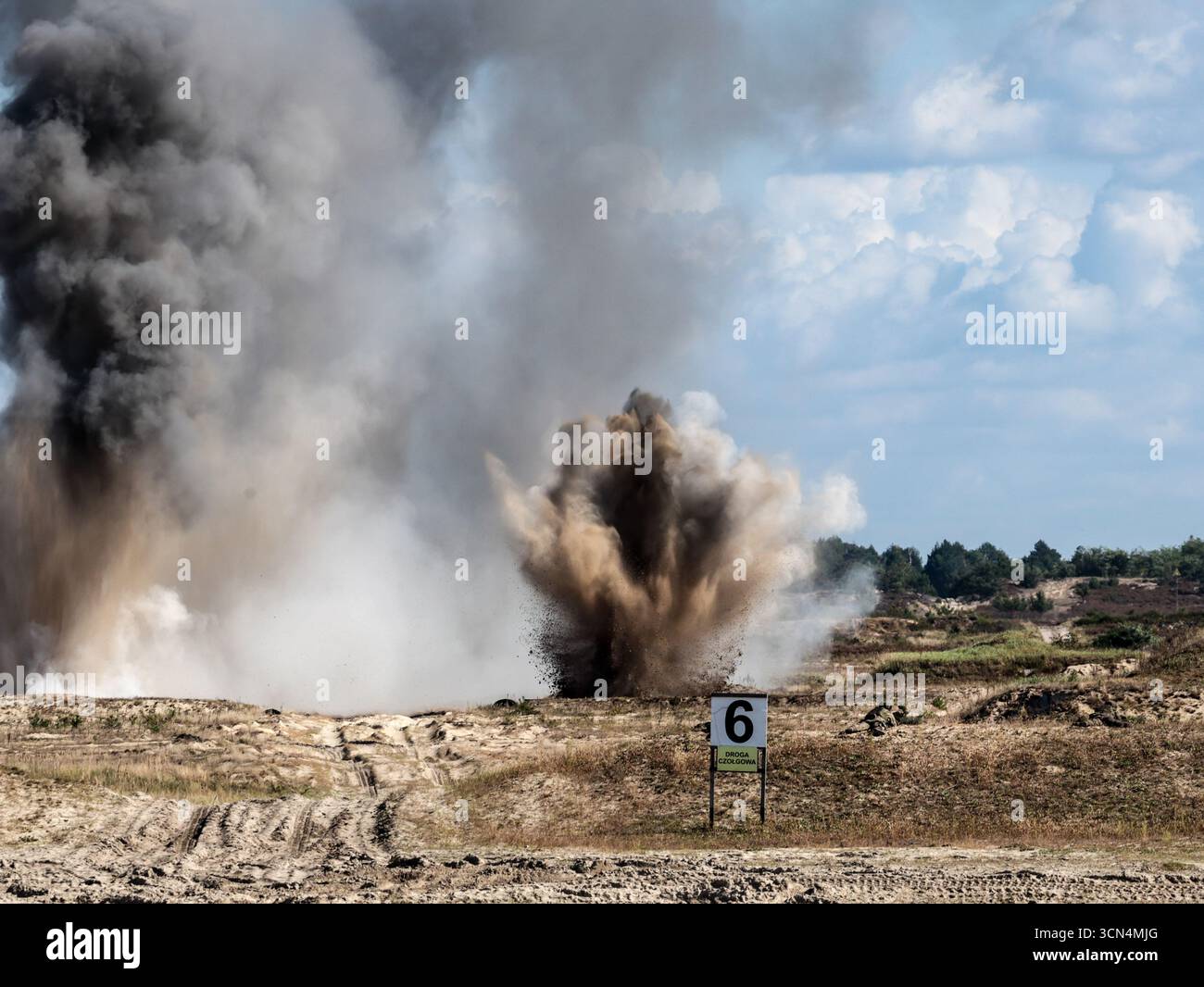 Explosions vues alors que des soldats d'infanterie polonais des Forces de défense territoriale s'entraînent à tirer à vue sous couvert lors de la journée médiatique Iron Defender 25. L’exercice Iron Defender 25 est l’événement d’entraînement le plus important et le plus important planifié par et pour les forces armées polonaises. Il s'agit d'une série d'exercices défensifs menés sur terre, dans les airs et sur l'eau par les forces terrestres, aériennes, navales, spéciales et territoriales de défense. Trente mille soldats et 600 pièces d'équipement des forces armées polonaises et des alliés de l'OTAN y participent. Banque D'Images