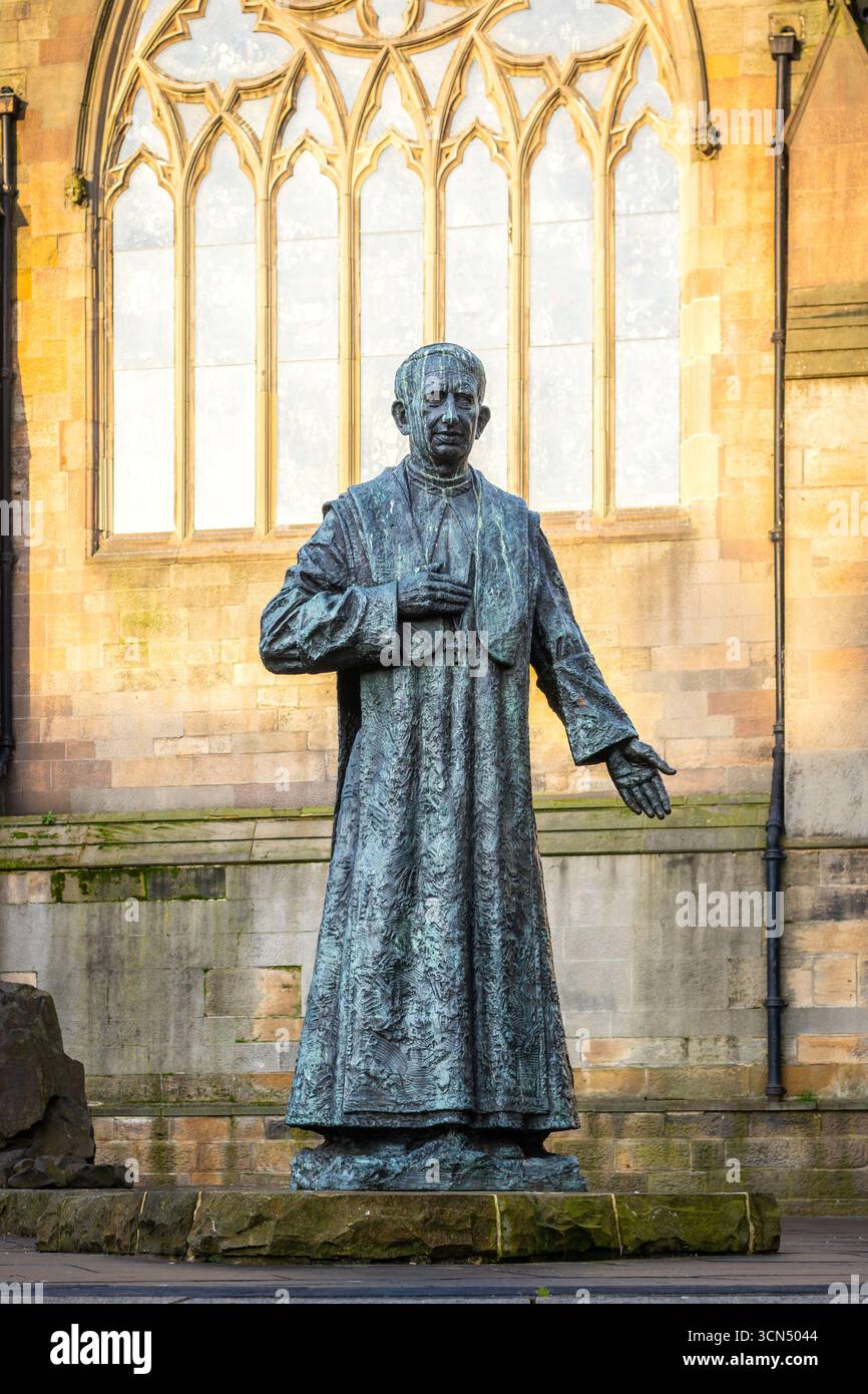 Statue en bronze de la figure historique cardinal basilic hume en tenue ecclésiastique par la sculpture Nigel Bonham Newcastle sur la façade de la cathédrale de tyne Banque D'Images