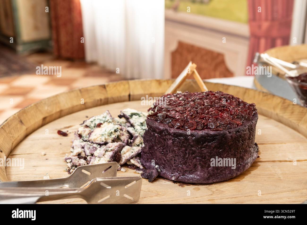 Le fromage de lavande aux canneberges et le fromage bleu aux herbes sont présentés sur un couvercle de fût en bois lors d'un buffet, prêt à être servi Banque D'Images