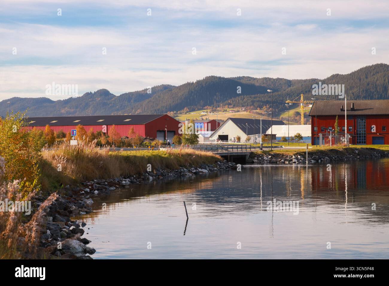 Orkanger Industrial Port View, Norvège. Paysage côtier avec granges en bois rouge undre ciel bleu nuageux Banque D'Images