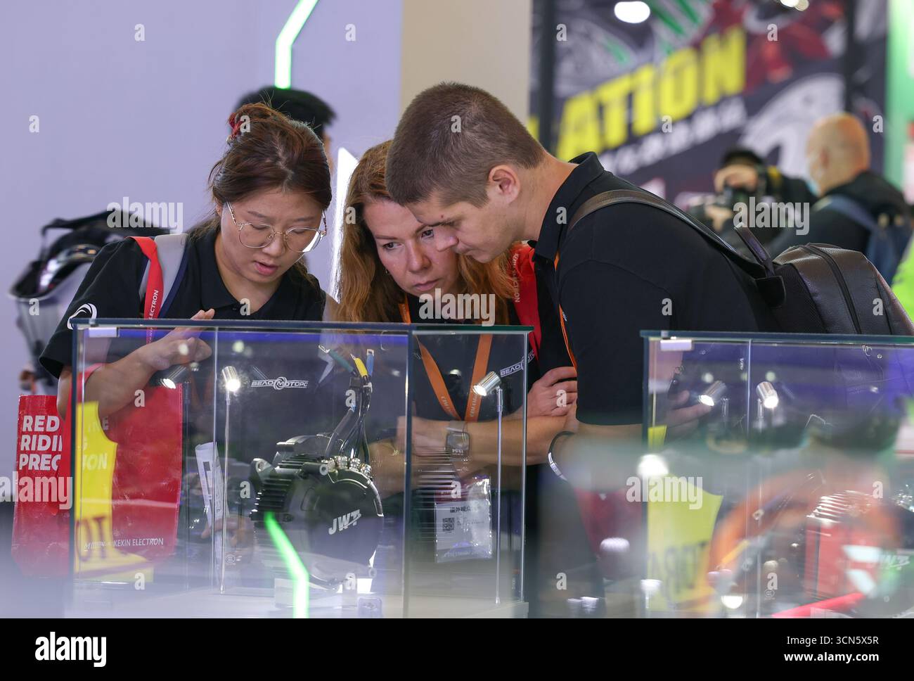 Chongqing, Chine. 19 septembre 2025. Les marchands apprennent à propos d'un moteur synchrone à aimant permanent pour moto lors d'une exposition internationale de moto à Chongqing, dans le sud-ouest de la Chine, le 19 septembre 2025. La 23ème exposition internationale de la moto en Chine se tient à Chongqing du 19 au 22 septembre, avec la participation de plus de 900 entreprises du monde entier. Crédit : Chen Cheng/Xinhua/Alamy Live News Banque D'Images