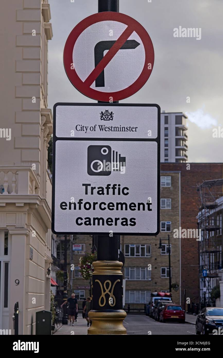 Panneau de stationnement réservé aux résidents à Westminster, Londres, affiché à côté d'un panier de fleurs suspendu. Banque D'Images