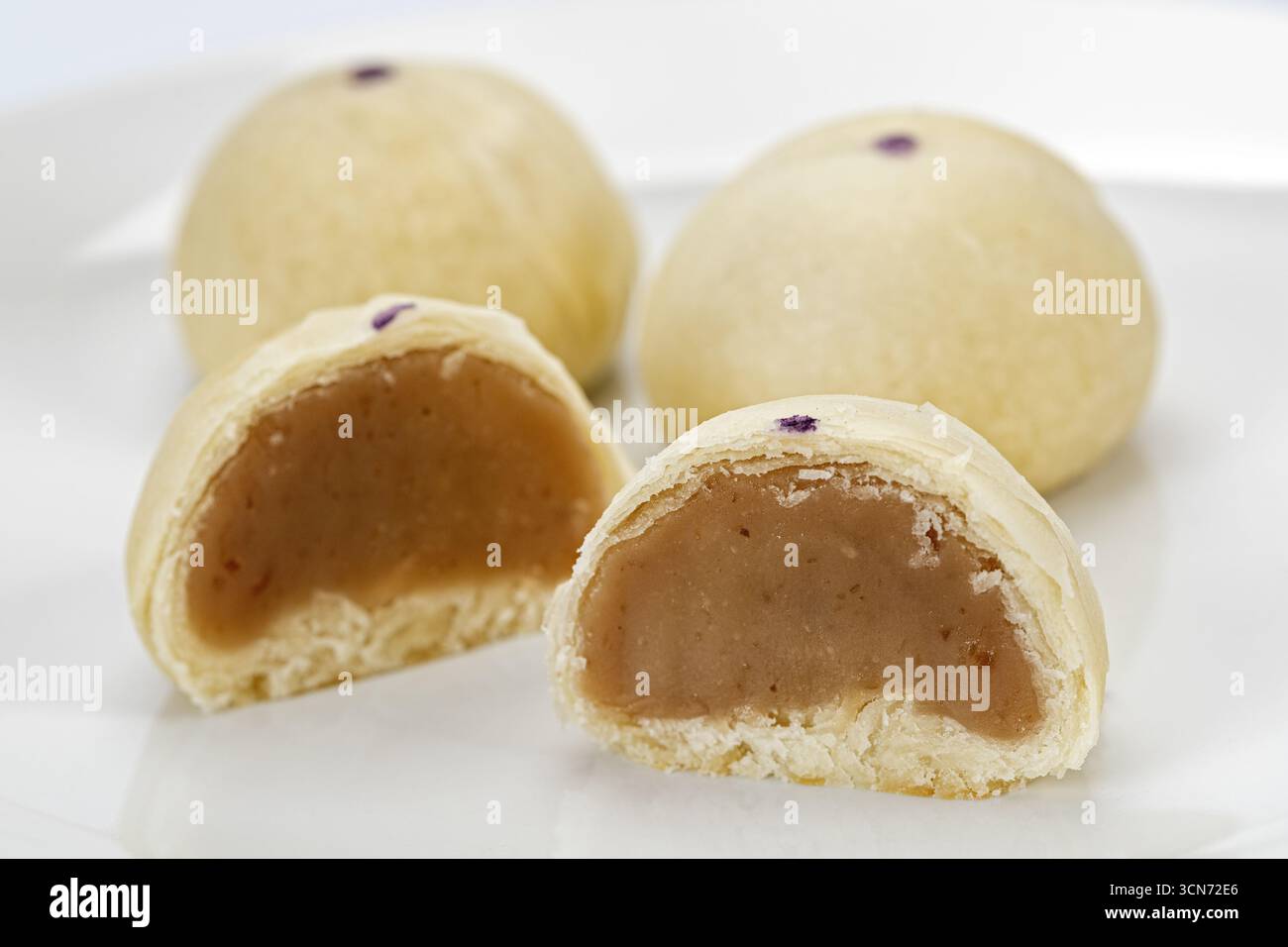 Taro gâteau de lune chinois croûte feuilletée taro sucré remplissage rond dessert traditionnel assiette blanche collation gros plan délicieuse pâtisserie asiatique Banque D'Images