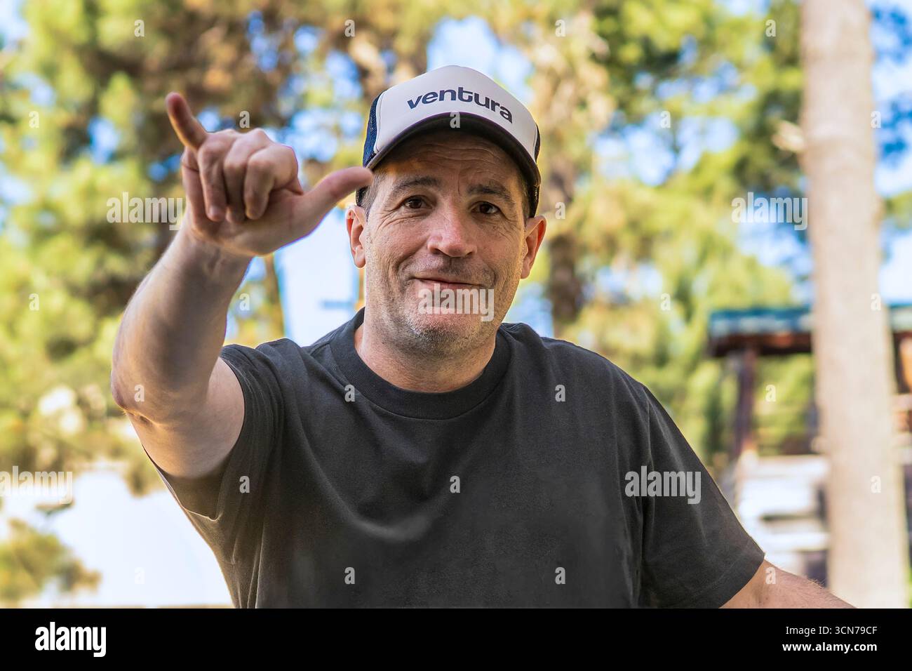 Surfeur dans une casquette faisant un geste de pendre lâche. Banque D'Images