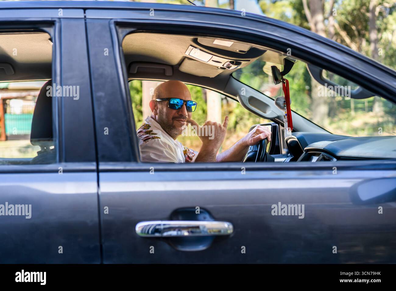 Homme conduisant un camion faisant un geste de pendaison lâche. Banque D'Images