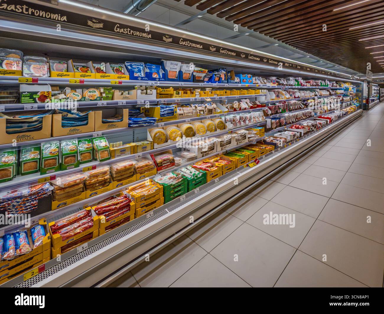 Verzuolo, Italie - 18 septembre 2025 : longue vitrine réfrigérée avec des aliments emballés, de la charcuterie et des fromages frais exposés à la vente chez MD superm Banque D'Images