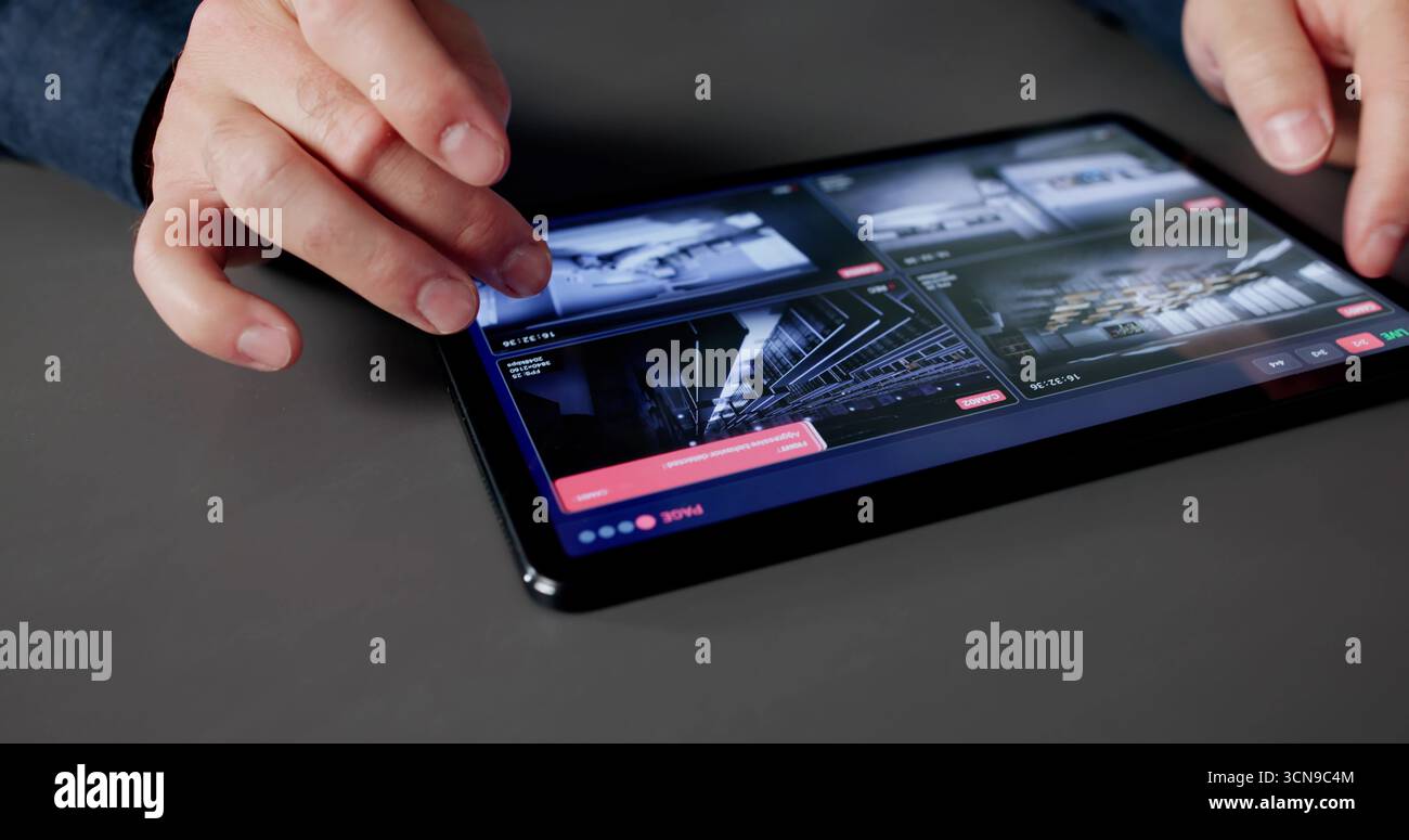 Man surveille Secure House Video System sur tablette pour la confidentialité. Banque D'Images