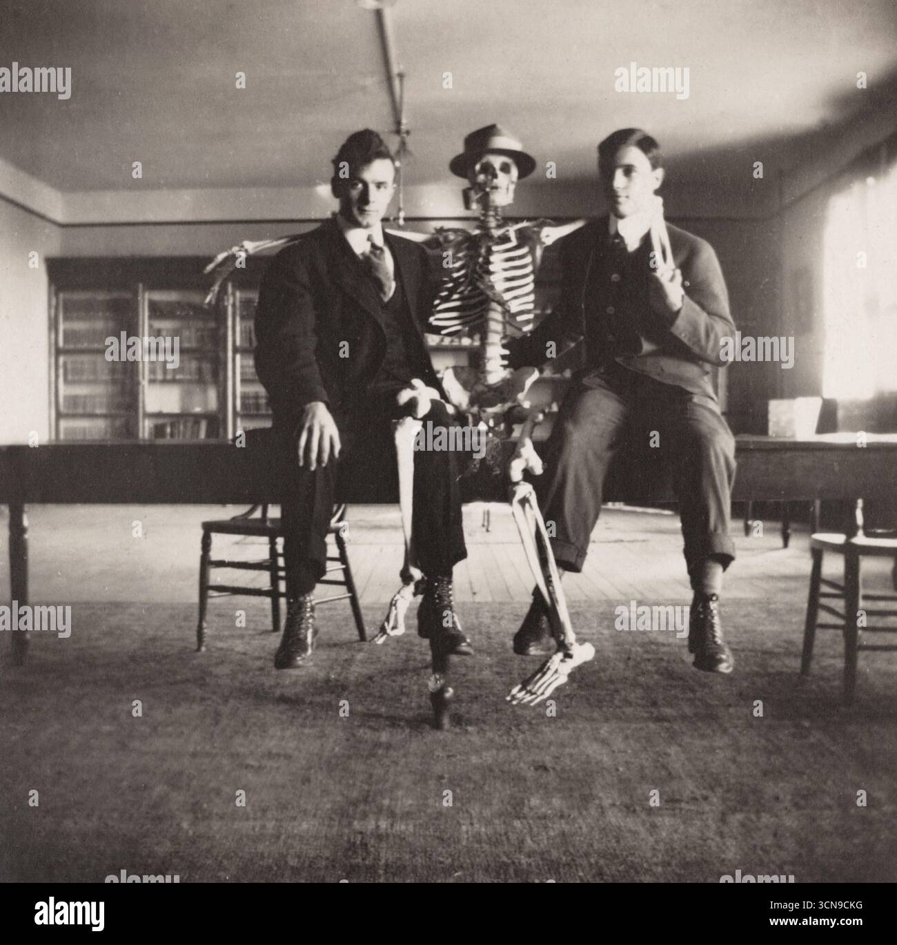 Deux hommes et squelette, (peut-être des étudiants en médecine en classe) début au milieu du XXe siècle photographie. photographe non identifié, *veuillez noter que cette image est floue Banque D'Images