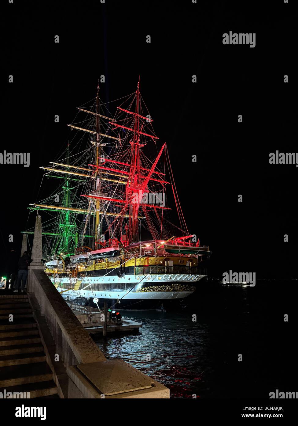 Le majestueux voilier Amerigo Vespucci de la Marine italienne a accosté à Riva San Biasio, illuminé la nuit avec les couleurs du drapeau italien, Venise - Image de stock capturée avec un smartphone