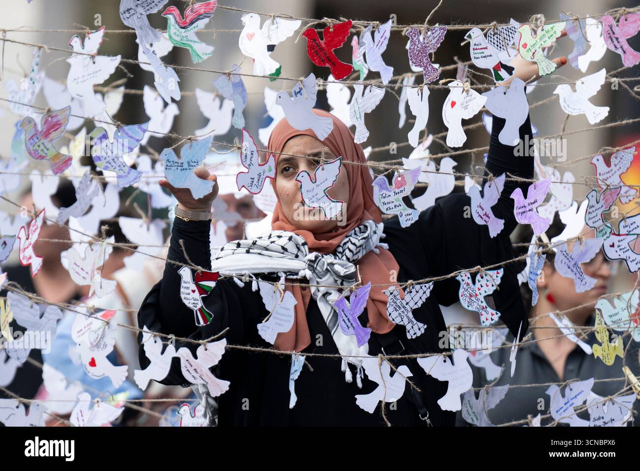 20 septembre 2025, Hesse, Francfort-sur-le-main : des militants pro-palestiniens ont accroché des centaines de colombes de paix symboliques en papier à l'occasion de la Journée mondiale de l'enfance, qui, selon les organisateurs, portent les noms d'enfants morts dans la guerre de Gaza. Photo : Boris Roessler/dpa Banque D'Images