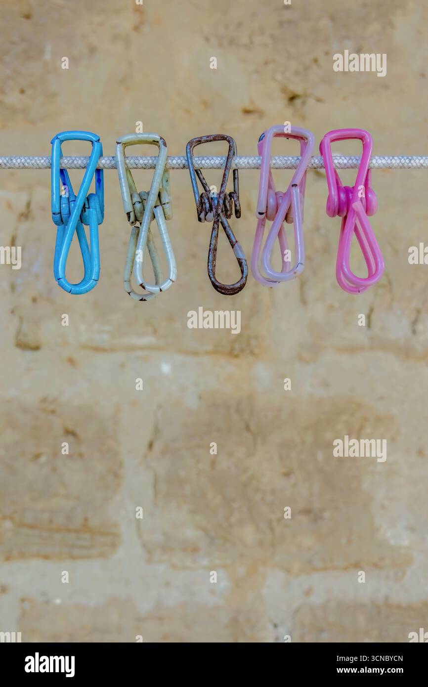Vieille pince à linge en métal coloré altéré recouverte de plastique, suspendue à un cordon contre un mur d'adobe, dans une maison de ferme dans les montagnes andines orientales Banque D'Images