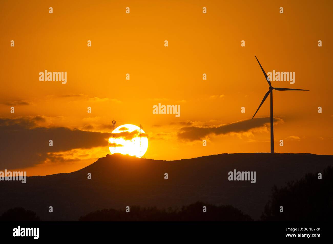Coucher de soleil doré sur des éoliennes et des collines ondulantes Banque D'Images