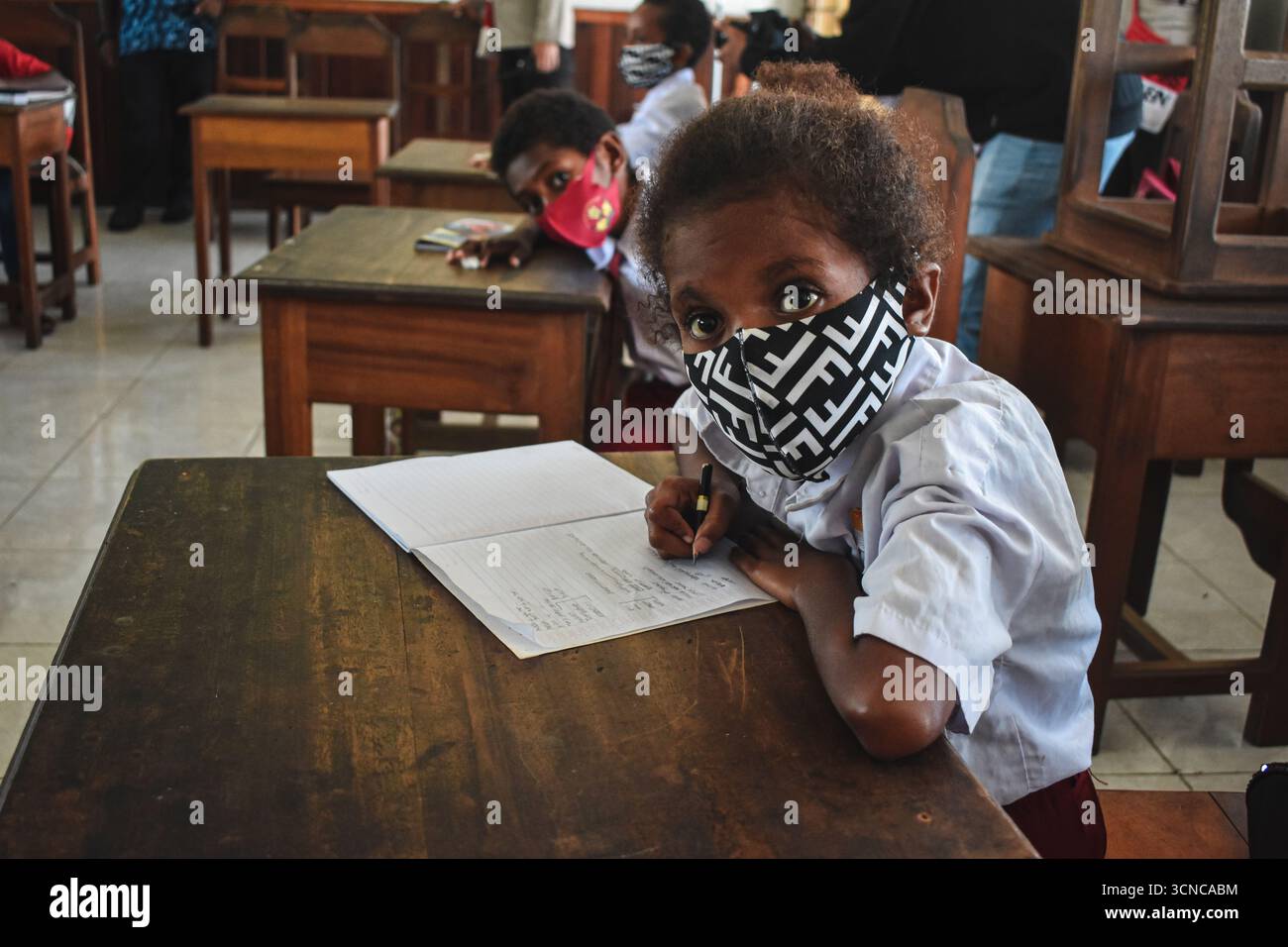 Enfants autochtones de Papouasie portant des masques étudiant en classe Banque D'Images