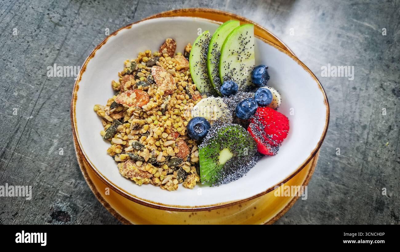 Bol de yogourt avec granola, bleuets, banane, pomme, fraise et kiwi. - Image de stock capturée avec un smartphone