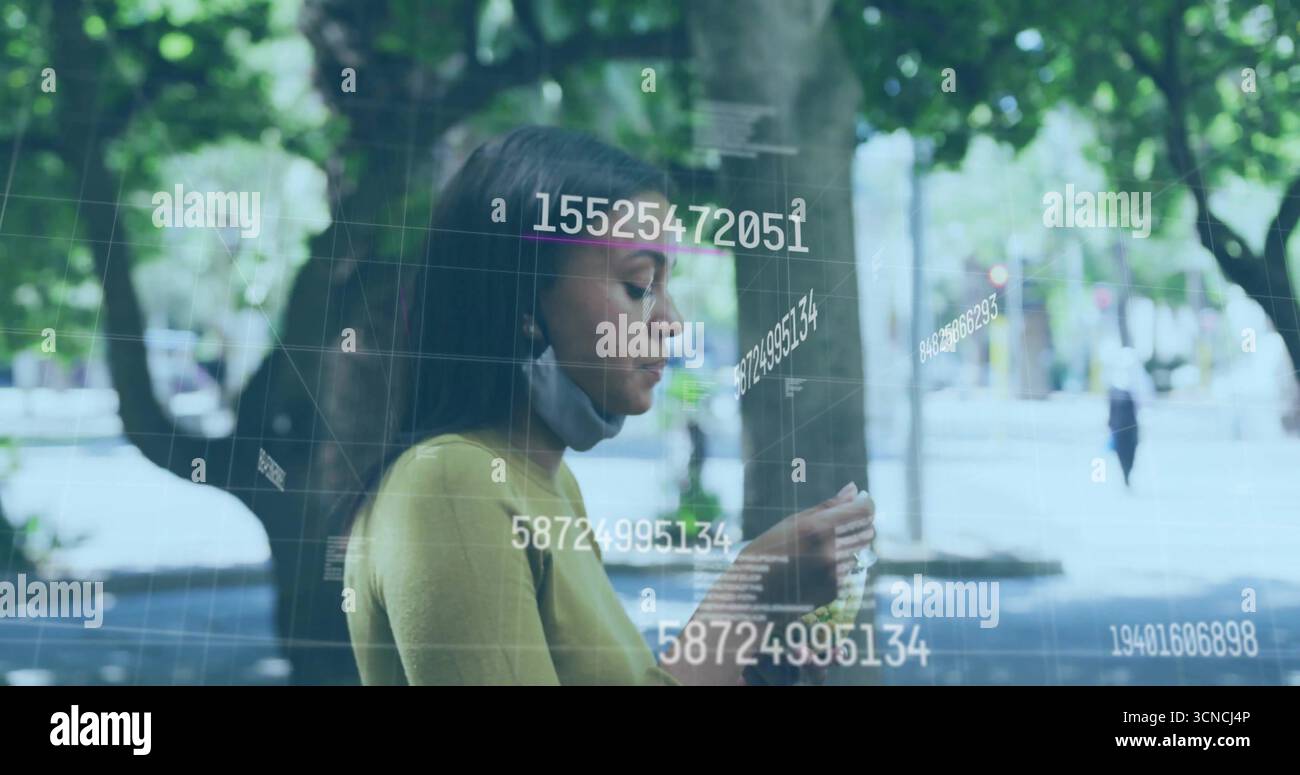 Affichage des données numériques de la grille sur smartphone sur le chemin bordé d'arbres portant le dessus moutarde et le masque sous le menton Banque D'Images