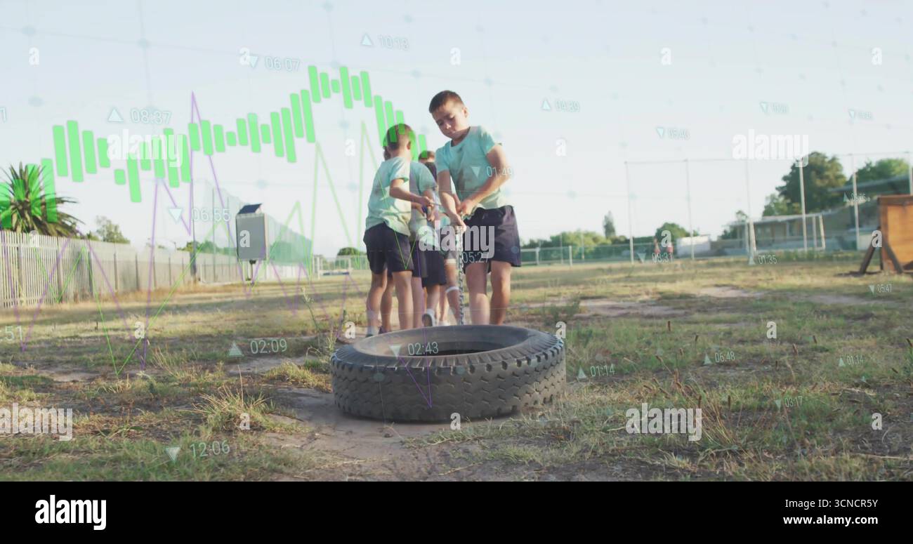 Tension six enfants tirant la corde sur le pneu du tracteur à l'aire de jeux de l'école, avec la clôture de maillons de chaîne Banque D'Images