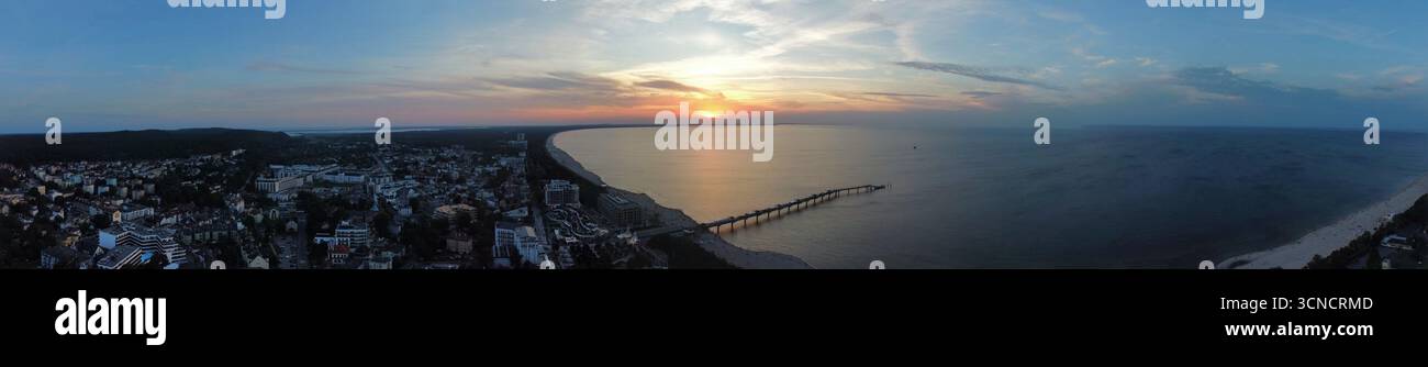Photo aérienne de la jetée à Międzyzdroje, Pologne. Prise au coucher du soleil avec mer, soleil et plage. Banque D'Images