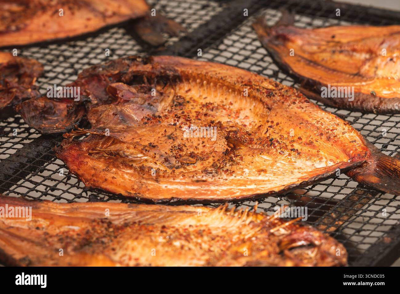 Gros plan de filets de poisson fumés sur un grill ou une grille de séchage dans un marché de rue fermier à Vilnius, Lituanie, prêt à manger Banque D'Images