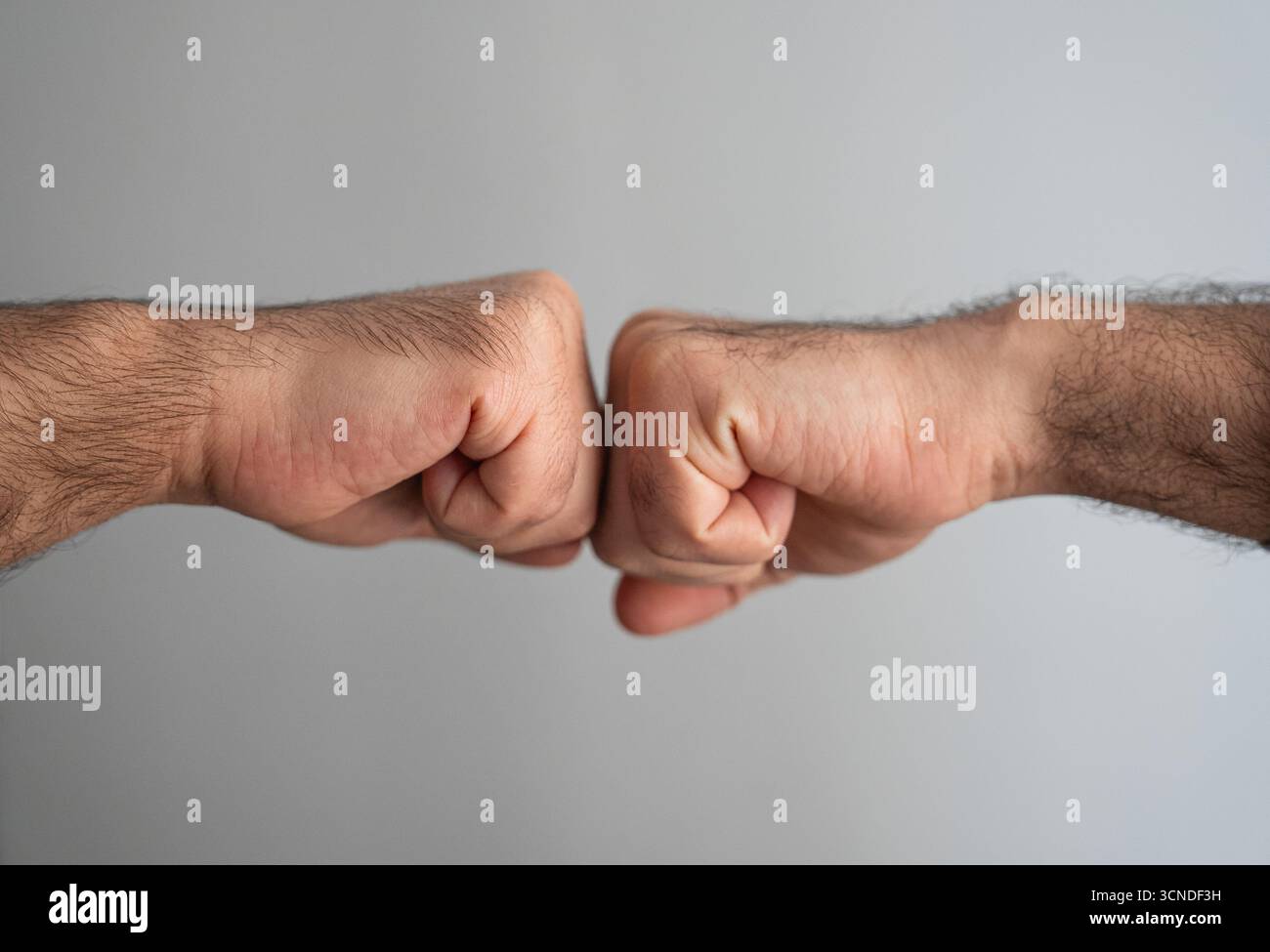 Mains masculines dans un geste de coup de poing. Symbole de confiance, de réussite commerciale et de soutien mutuel. Banque D'Images