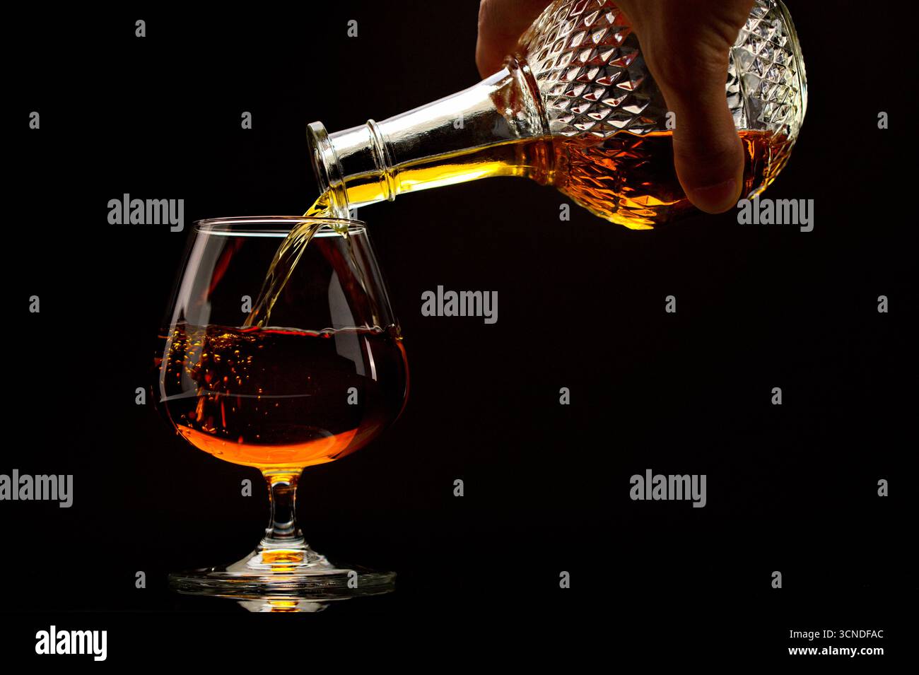 Une personne verse une boisson dans un verre. La boisson est un type d'alcool, et le verre est un verre à vin. Concept de détente et de plaisir, comme le p Banque D'Images