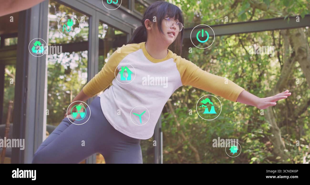 Équilibre enfant chinois portant chemise raglan et leggings au pavillon de verre avec des icônes éco flottantes Banque D'Images