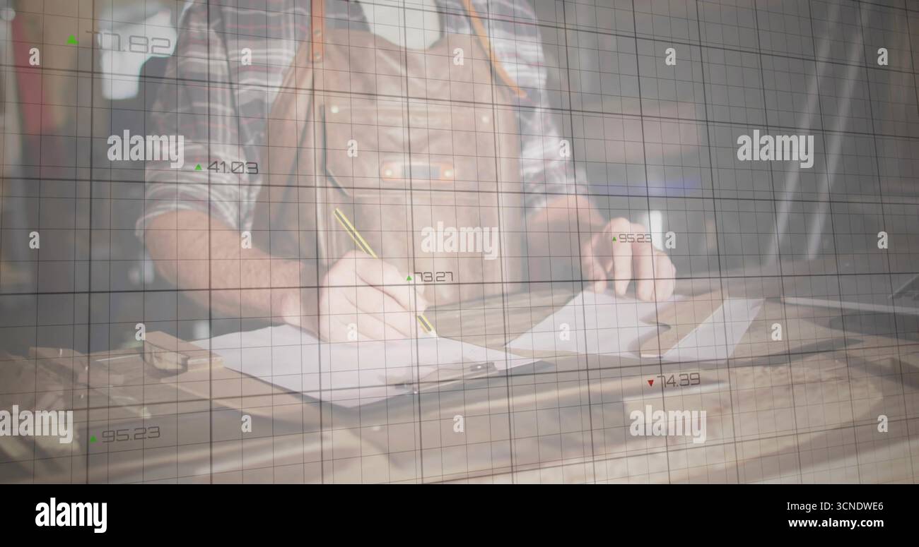 Dessinant artisan portant un tablier en cuir dessinant des plans sur papier au banc de studio, avec superposition de grille Banque D'Images