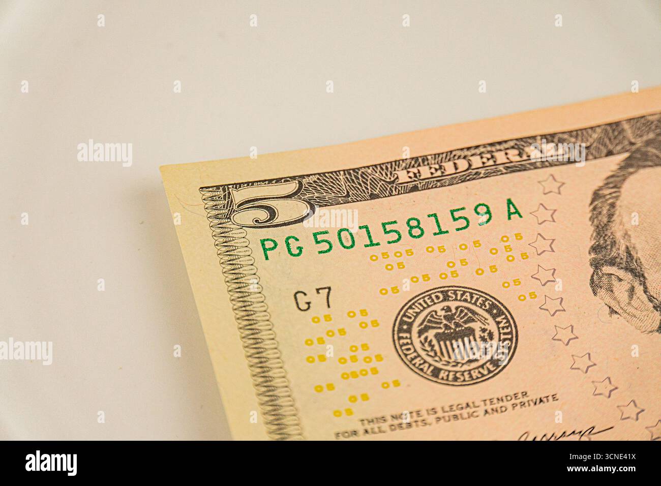 L'image montre un billet de cinq dollars avec le numéro de série 515879, représentant le président Abraham Lincoln il porte les phrases dans God We Trust et Uni Banque D'Images