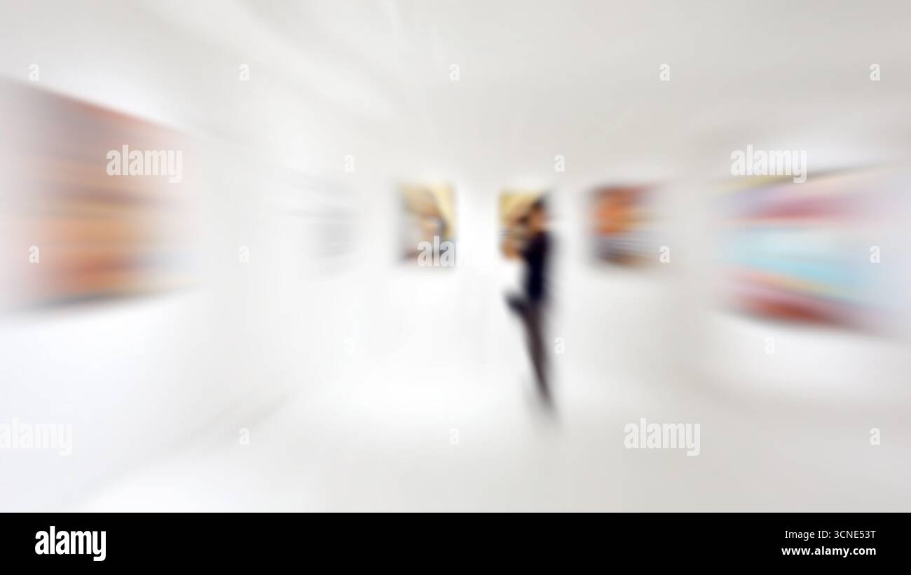 Motion blur, Un photographe photographie travaille dans une exposition dans une galerie, peinture abstraite colorée sur fond blanc Banque D'Images
