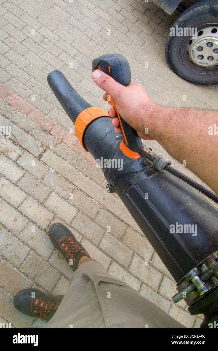Souffleur de feuilles avec sac à dos moteur essence en action. EQUIPEMENT moteur pour travaux de jardinage propres Banque D'Images