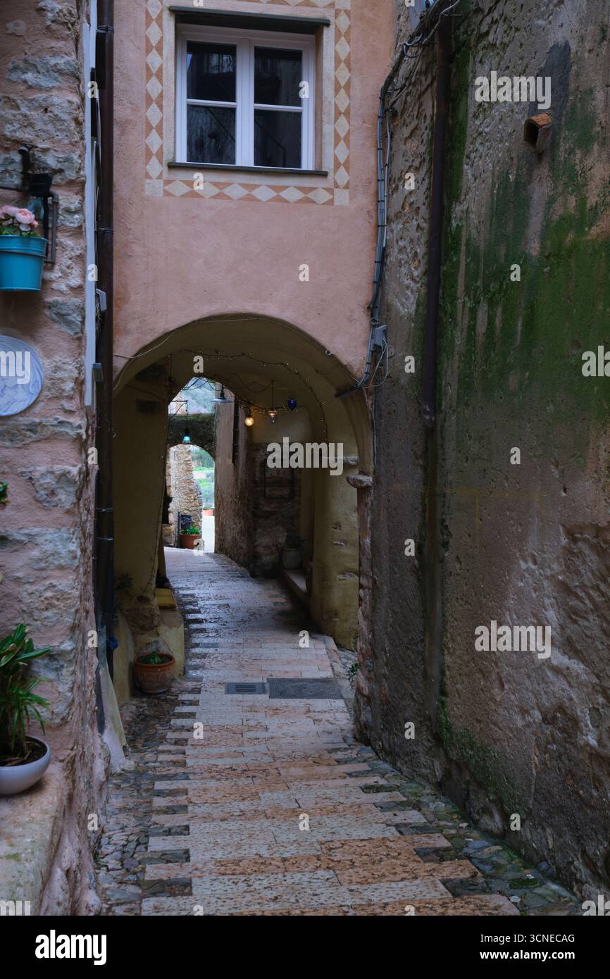 Vue en bas d'une voie de marche, voûtée sur une journée grise, pluvieuse et humide. Romantique avec lumières scintillantes. Dans le village rural de Borgio Verezzi. En Ligurie, Italie. Banque D'Images