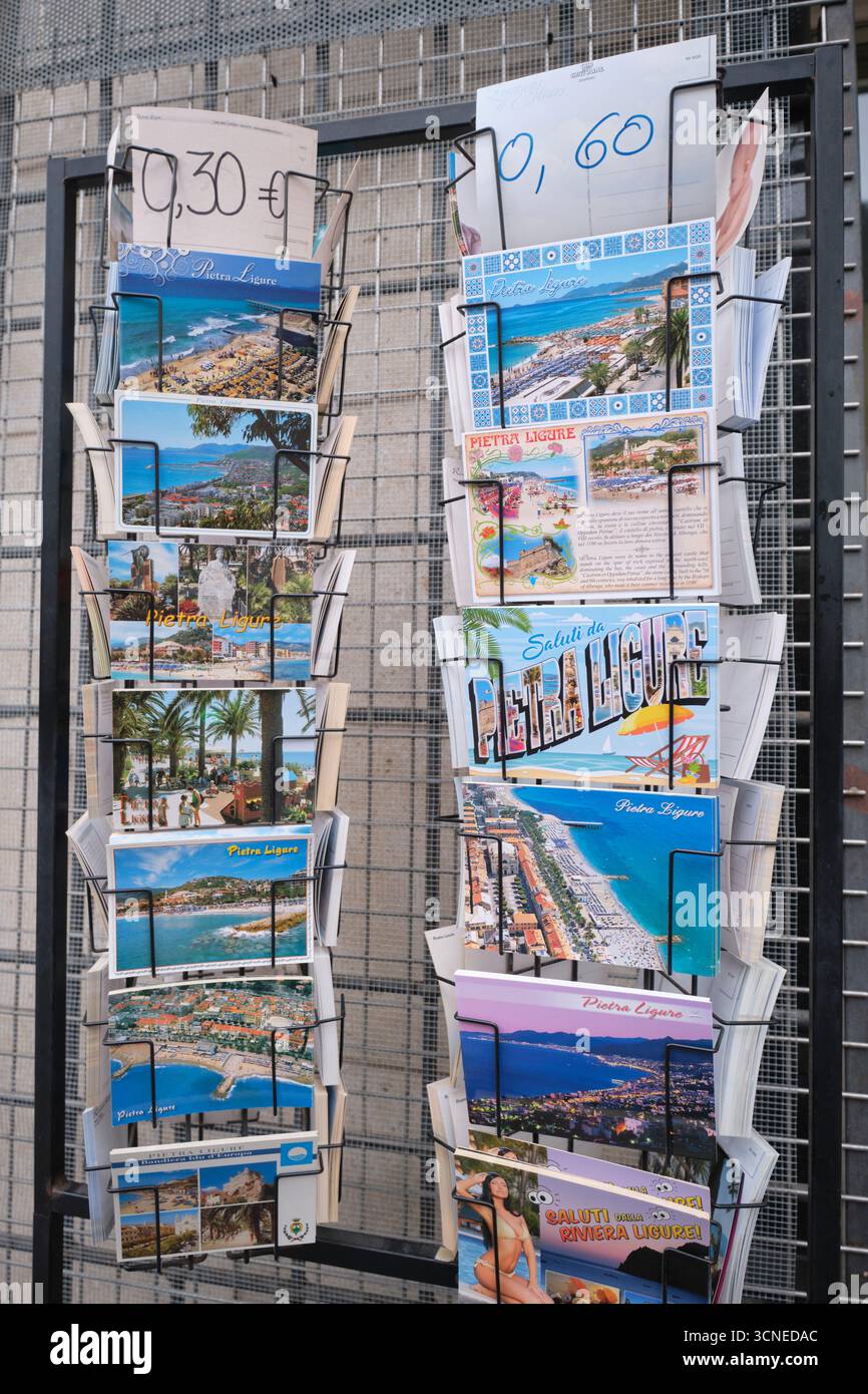Diverses photos de cartes postales en couleur à vendre sur un rack dans un magasin de souvenirs. Dans la ville balnéaire de Pietra Ligure, Ligurie, Italie. Banque D'Images
