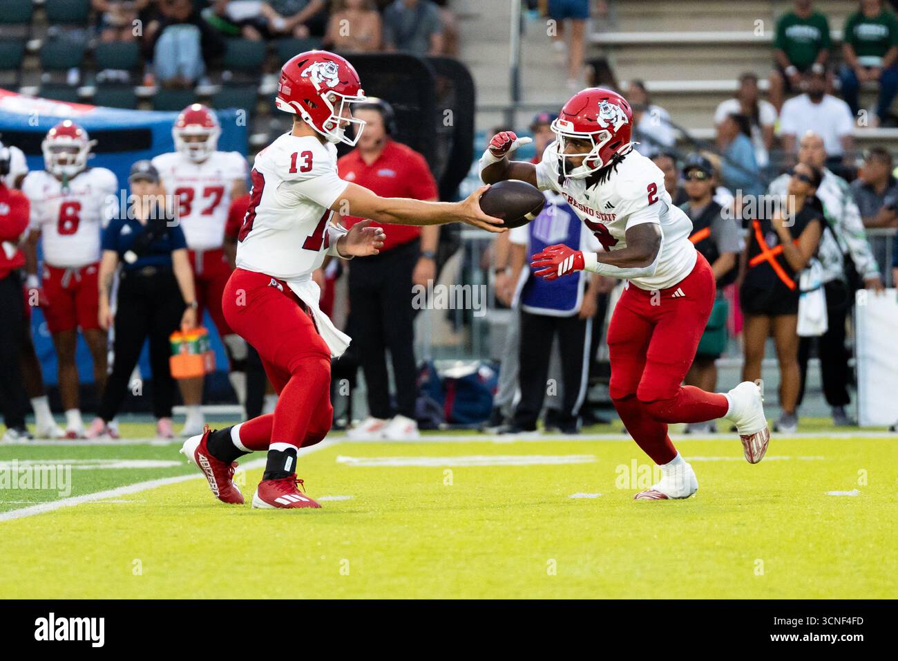 Honolulu, Hawaï, 20 septembre 2025. (L) le quarterback #13 E.J. Warner de Fresno State remet la main à (R) le Runback #2 Rayshon Luke dans Mountain West Open Play et la victoire 23 à 21 des Bulldogs sur les Warriors de l'Université de Hawai'i. Crédit : Solomon Thompson/Alamy Live News Banque D'Images